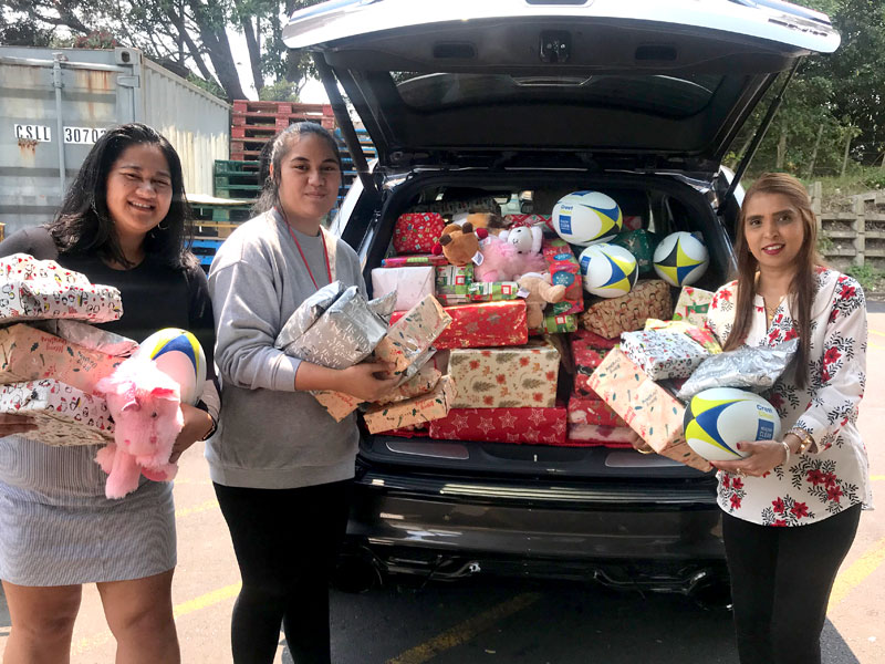 Salvation Army volunteers Nelly Losefo and Sammi Rei Losefo receive the presents from Nileshna Narayan.