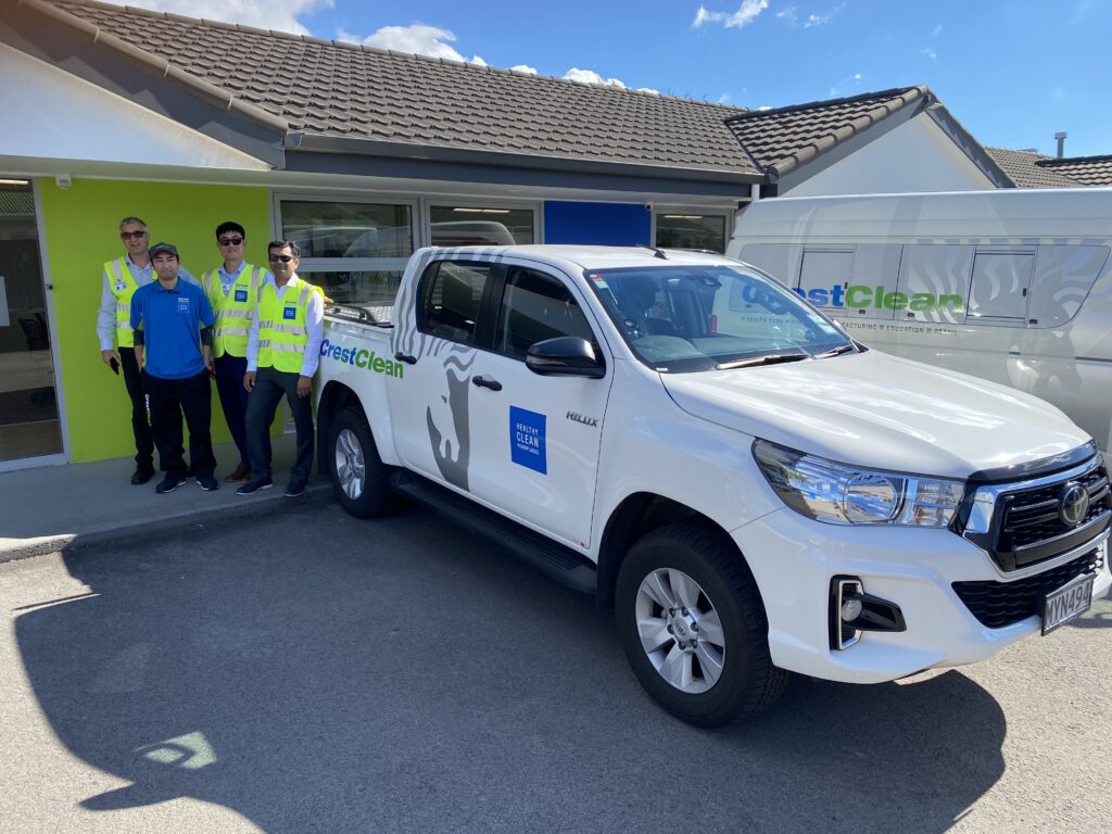Vehicle inspection personnel beside a cleaning truck.