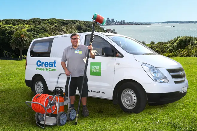 Property maintenance worker holding equipment in front of van
